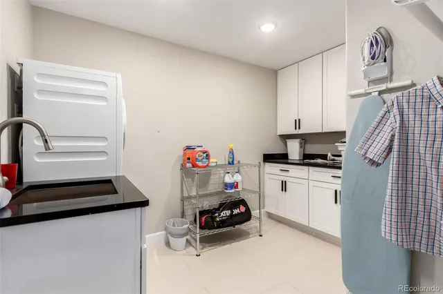 a kitchen with white cabinets and appliances