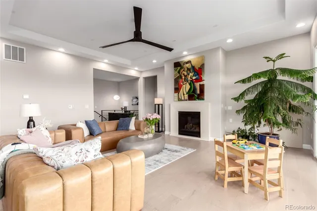 a living room with furniture a fireplace and potted plants