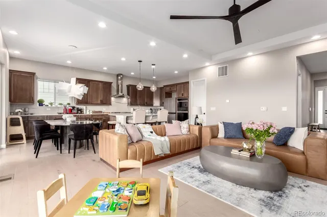 a living room with furniture kitchen and a chandelier
