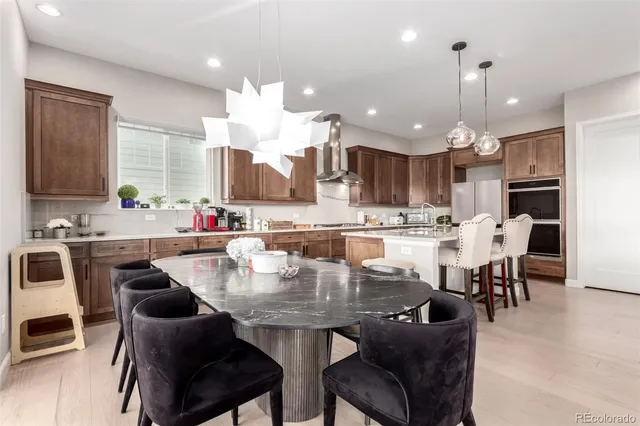a kitchen with kitchen island a dining table chairs sink and cabinets