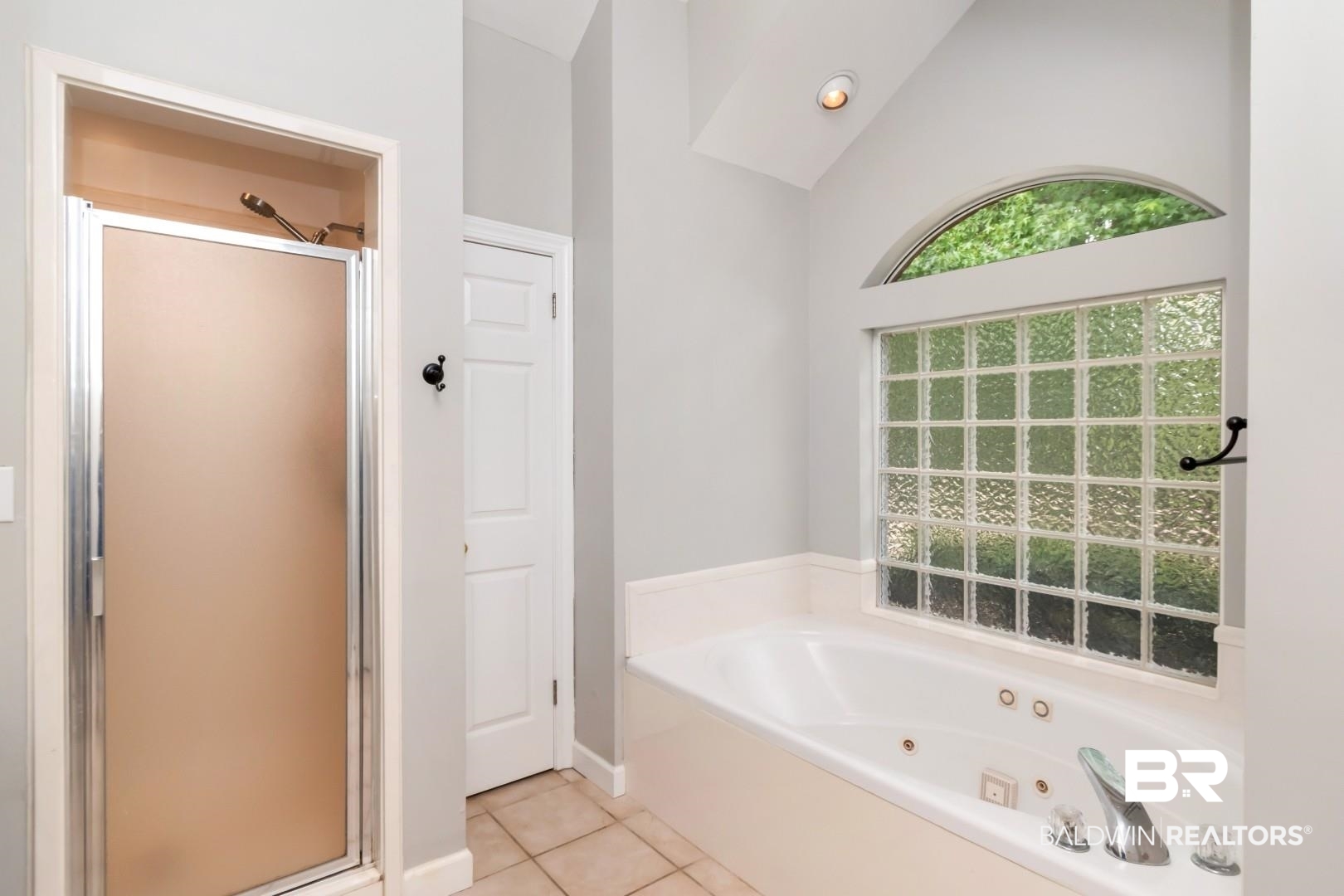 10691 Hunters Ridge Drive Mobile, AL 36695 - Photo 17 of 37 Soaking tub featuring chrome fixtures, a glass block window, and an arched transom window