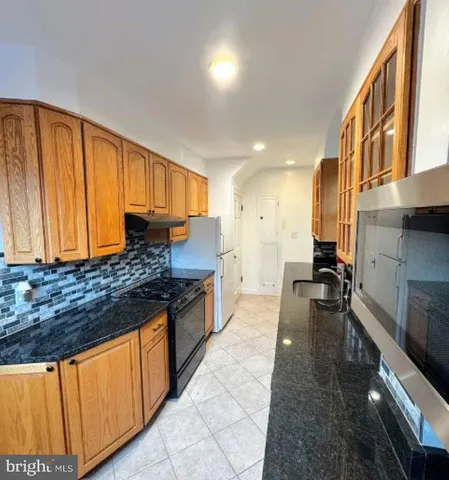 a large kitchen with stainless steel appliances granite countertop a stove a sink dishwasher and cabinets