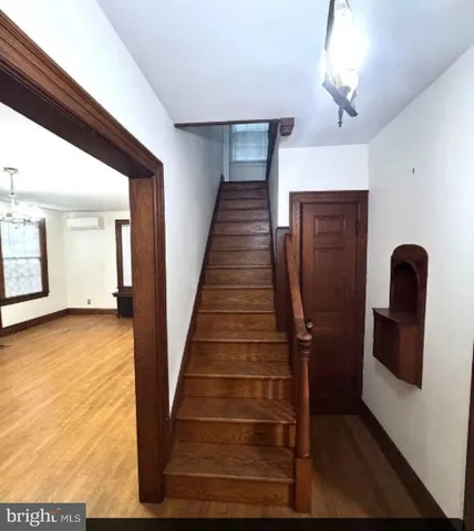 a view of a hallway with wooden floor and staircase