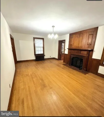 an empty room with windows fireplace and sink