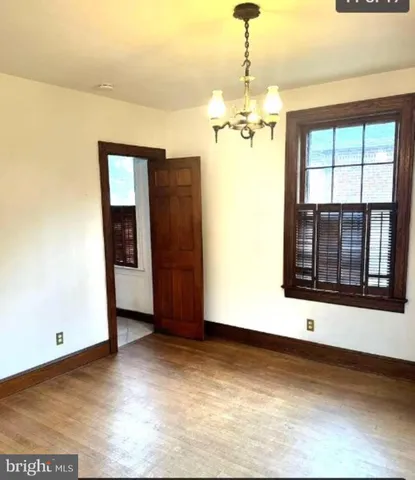 a view of a room with wooden floor and chandelier