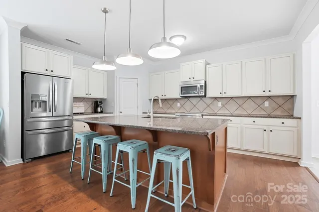 a kitchen with stainless steel appliances a stove a sink island and a refrigerator