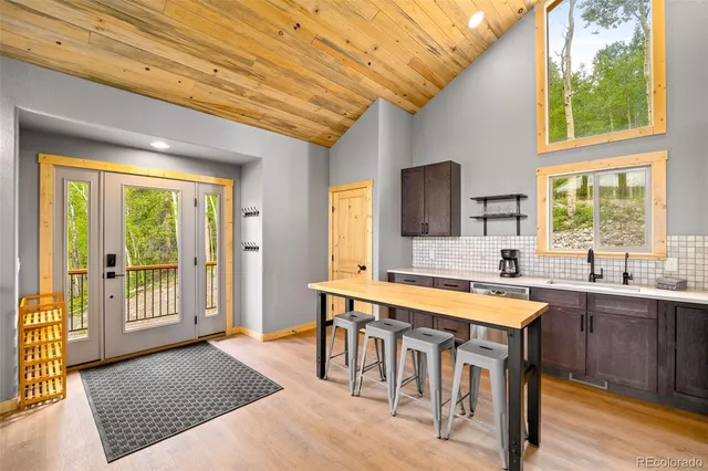 a dining hall with stainless steel appliances granite countertop a stove a sink a refrigerator and a dining table with garden view