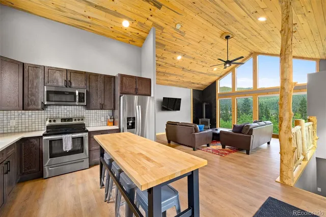 a kitchen with stainless steel appliances wooden floor dining table and chairs