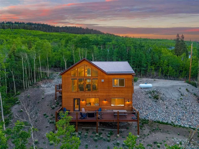 a view of a big house with a big yard and large trees