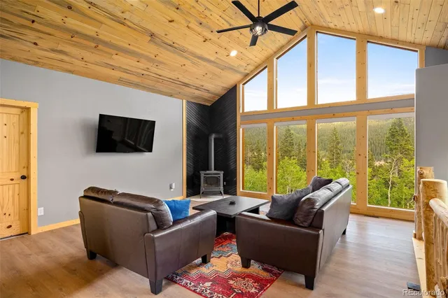 a living room with furniture a flat screen tv and a floor to ceiling window