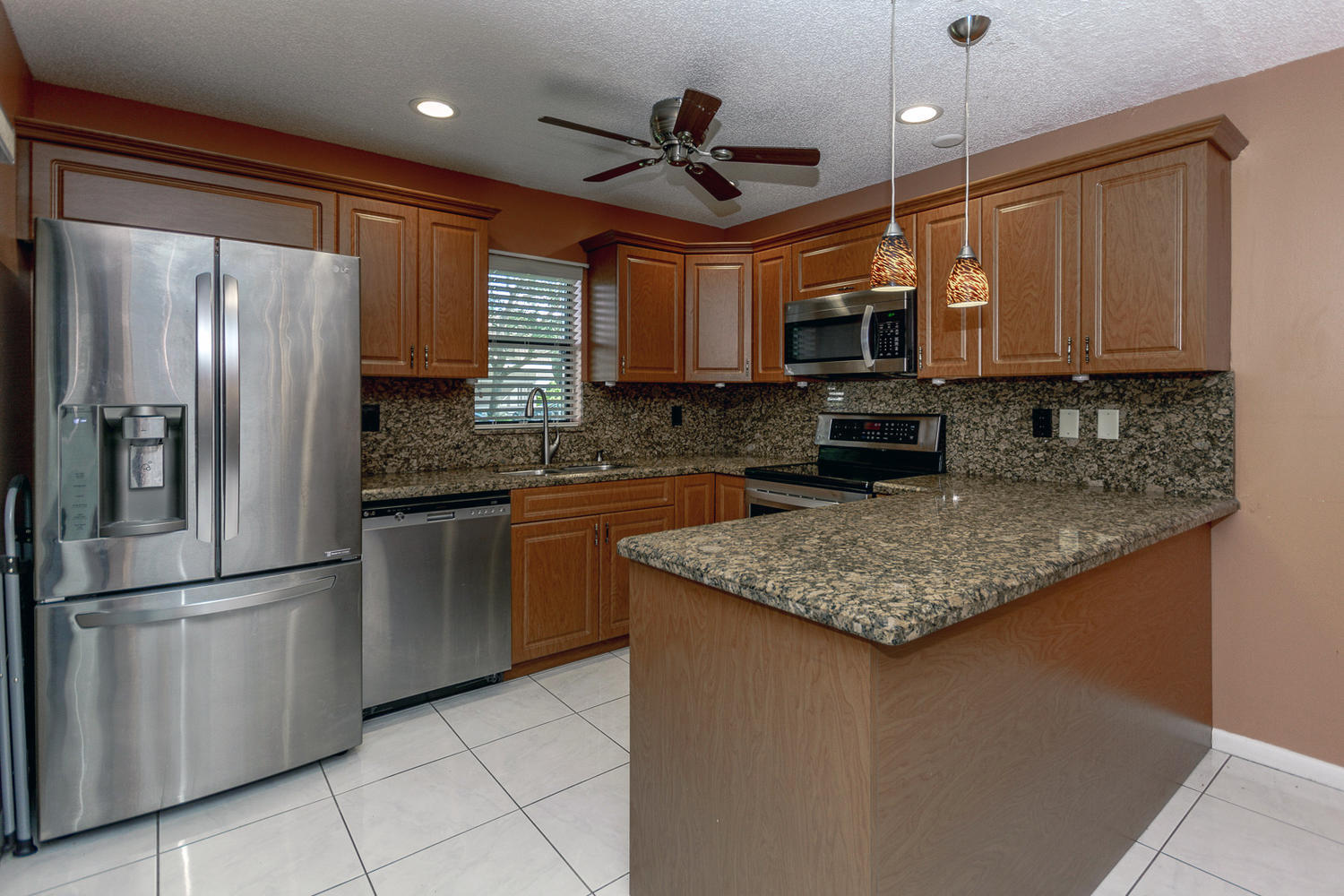 9370 Southwest 61st Way, Unit A Boca Raton, FL 33428 - Photo 1 of 19 a kitchen with stainless steel appliances granite countertop a refrigerator a stove a sink and a microwave