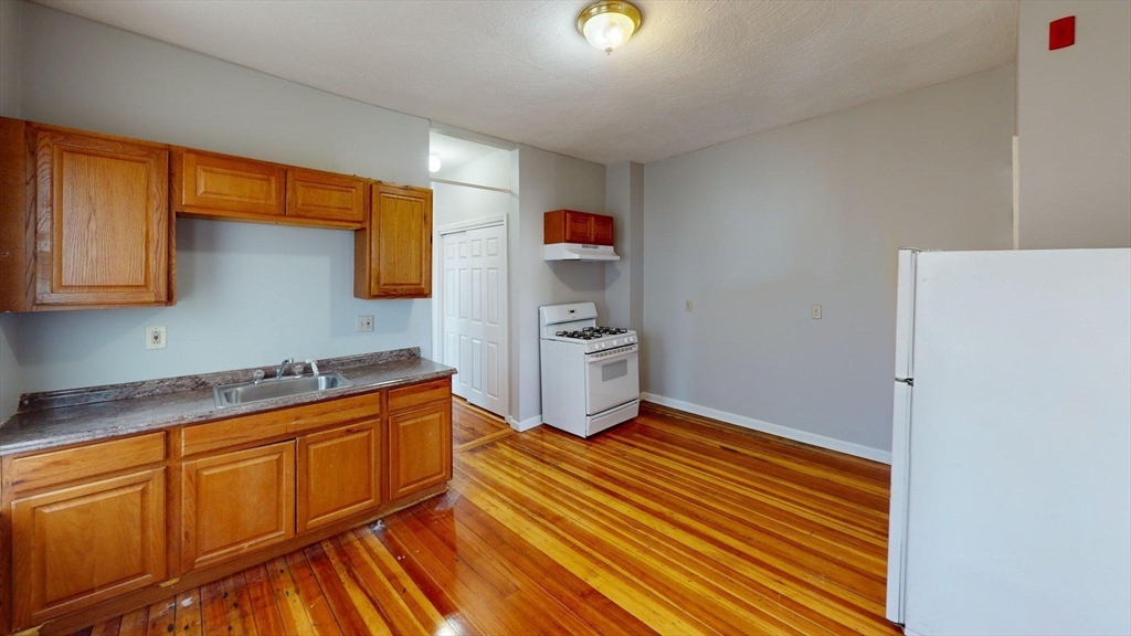 52 Sumner Street, Unit 3 Revere, MA 02151 - Photo 2 of 7 a kitchen with stainless steel appliances granite countertop a sink stove and refrigerator