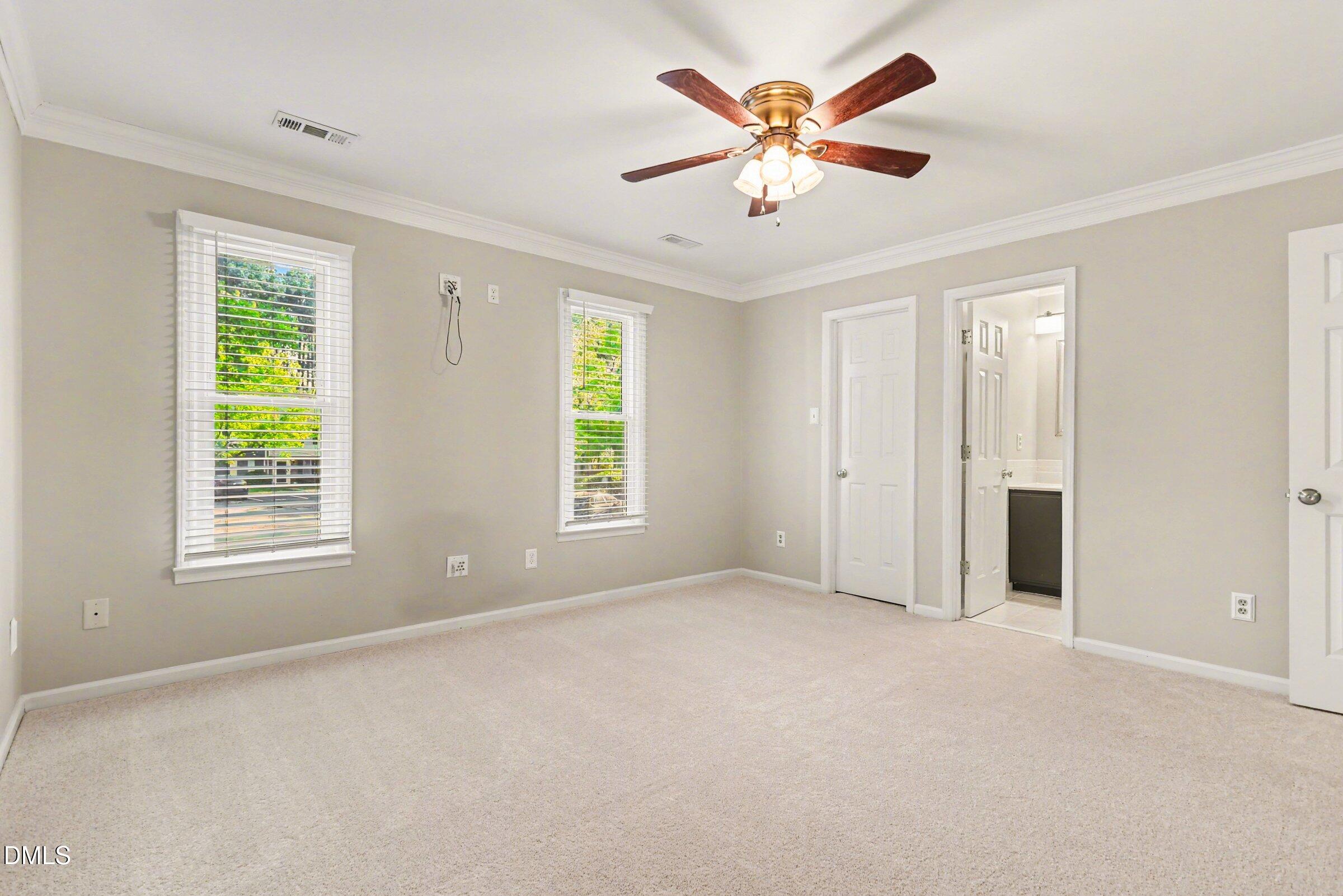 5645 Hamstead Crossing Raleigh, NC 27612 - Photo 17 of 35 an empty room with windows and a chandelier fan