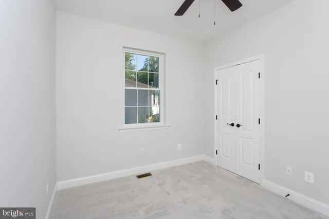 an empty room with closet and windows