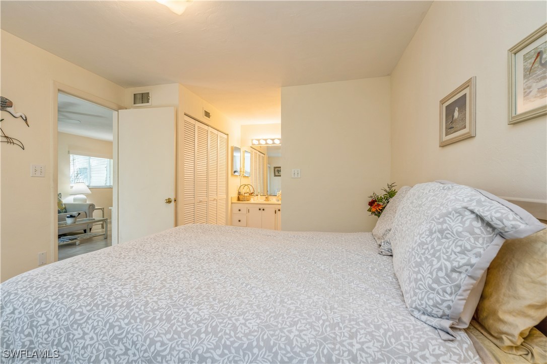 8049 Country Road, Unit 102 Fort Myers, FL 33919 - Photo 10 of 23 a bedroom with a bed and wooden floor