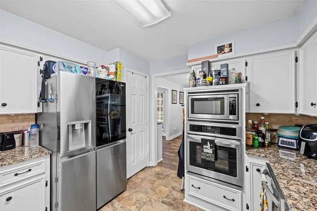 a kitchen with stainless steel appliances a stove a refrigerator and cabinets