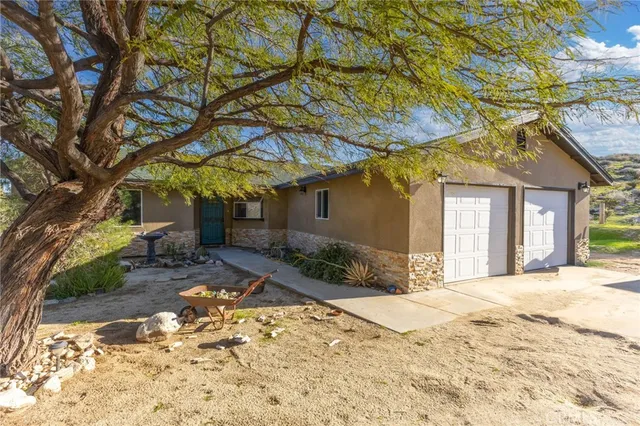 a view of a house with a yard and tree