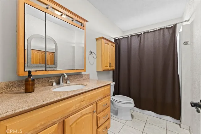a bathroom with a double vanity sink toilet and a mirror