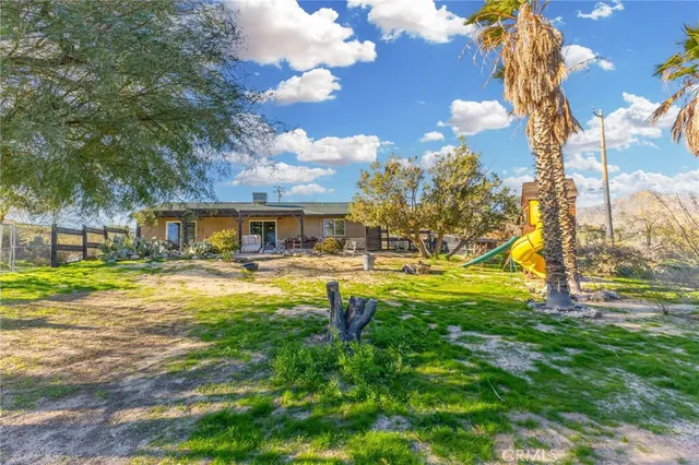 a house view with swimming pool and trees in the background