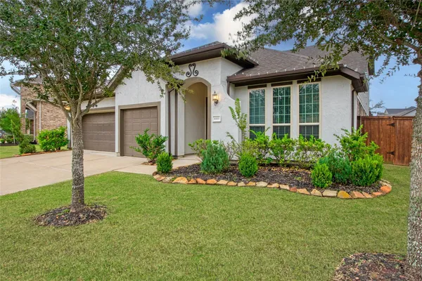 a front view of a house with a garden and plants