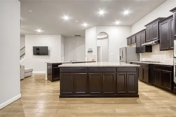 a kitchen with stainless steel appliances granite countertop a stove a sink and a microwave