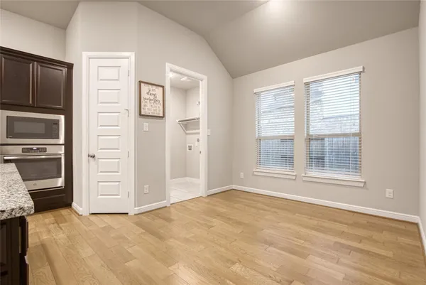a view of an empty room with a kitchen and a window