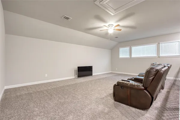 a living room with furniture and a ceiling fan