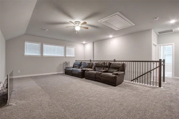 a backyard of a house with plants and large tree