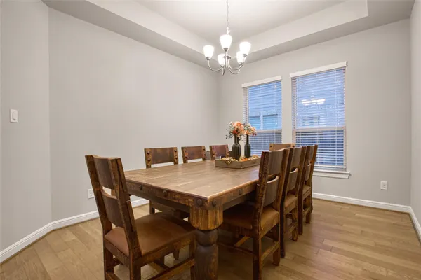 a view of a dining room with furniture a chandelier and wooden floor