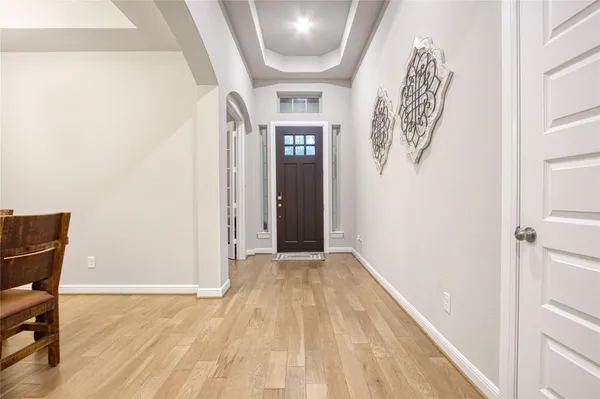 a view of a hallway to a livingroom with furniture and wooden floor