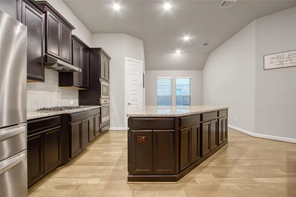a kitchen with stainless steel appliances granite countertop a stove and a sink