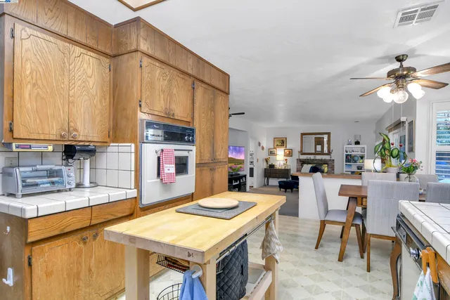 a kitchen with a stove a sink a dining table and chairs