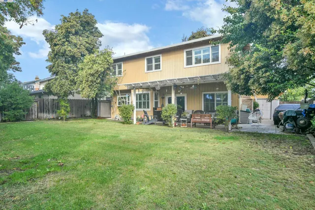 a view of a patio with table and chairs potted plants and floor to ceiling window