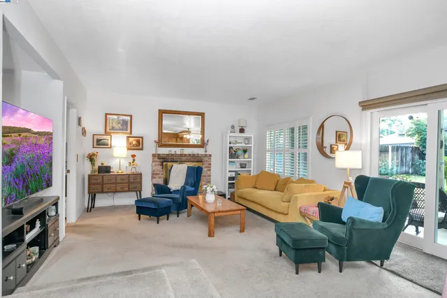 a living room with furniture a fireplace and a flat screen tv