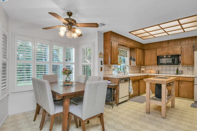 a dining room with stainless steel appliances a table and chairs
