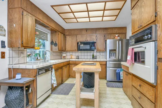 a kitchen with stainless steel appliances granite countertop a sink a stove and a refrigerator