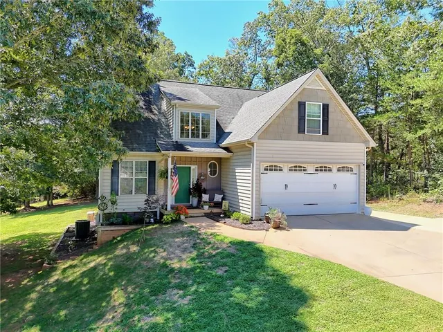 a view of a house with a yard and sitting area