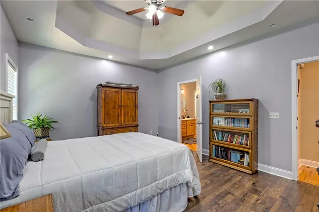 a dining room with stainless steel appliances kitchen island granite countertop a refrigerator a stove and white cabinets with wooden floor