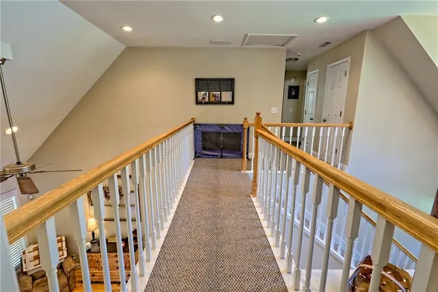 a view of a hallway with wooden floor and staircase