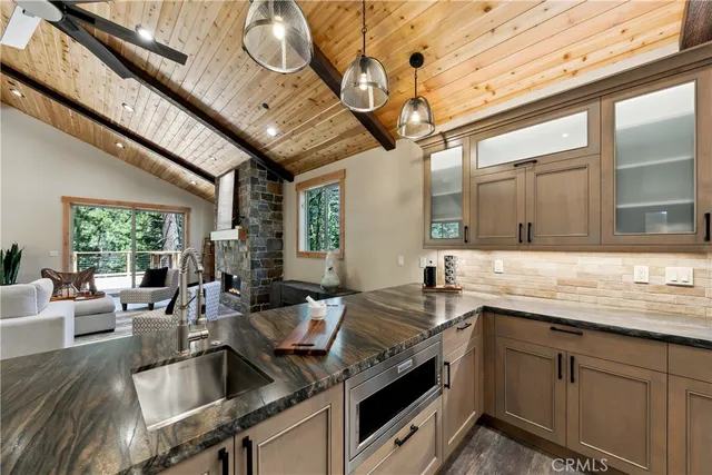 a view of a kitchen with stainless steel appliances granite countertop a sink and cabinets