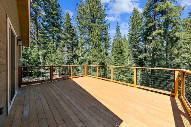 a view of a balcony with wooden floor and fence