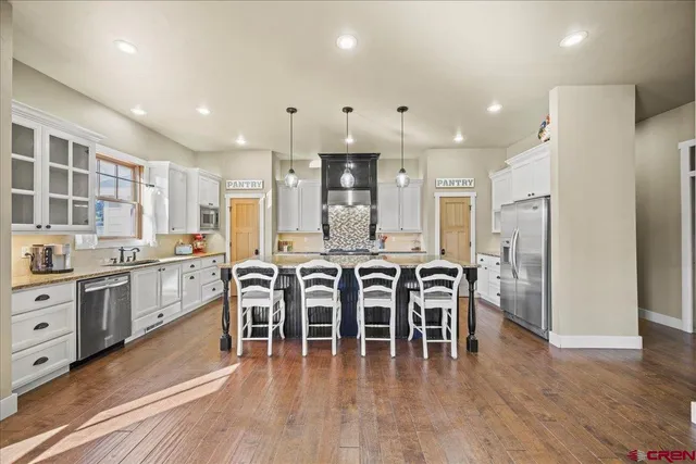 a kitchen with granite countertop a stove a sink and a refrigerator