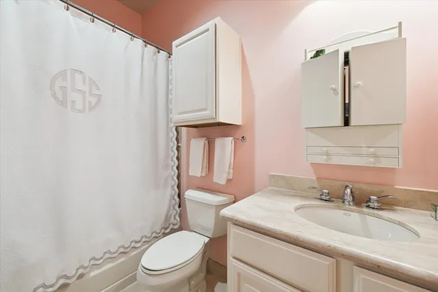 a bathroom with a granite countertop sink a toilet and a mirror
