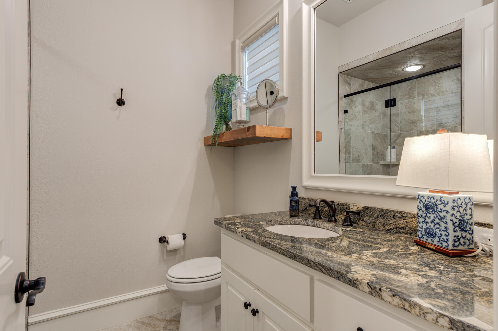 5006 117th Street Lubbock, TX 79424 - Photo 42 of 88 a bathroom with a granite countertop sink a toilet and a mirror