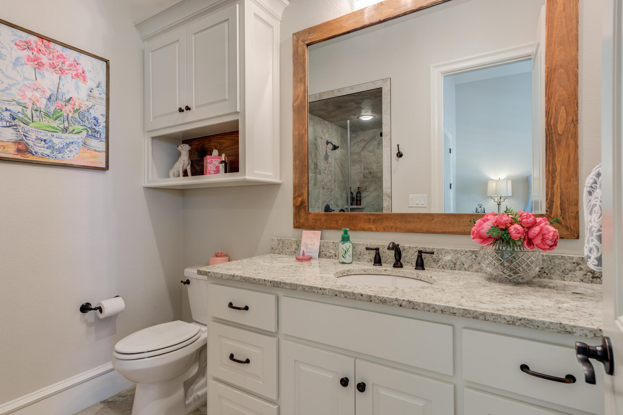 5006 117th Street Lubbock, TX 79424 - Photo 49 of 88 a bathroom with a granite countertop toilet sink and mirror