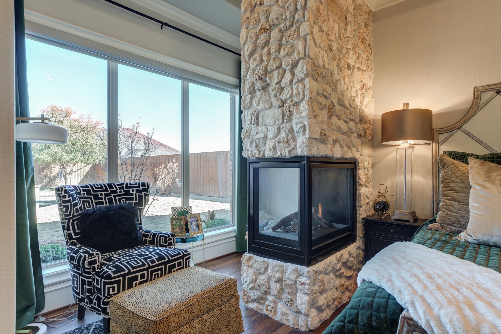 5006 117th Street Lubbock, TX 79424 - Photo 56 of 88 a living room with furniture a fireplace and a floor to ceiling window