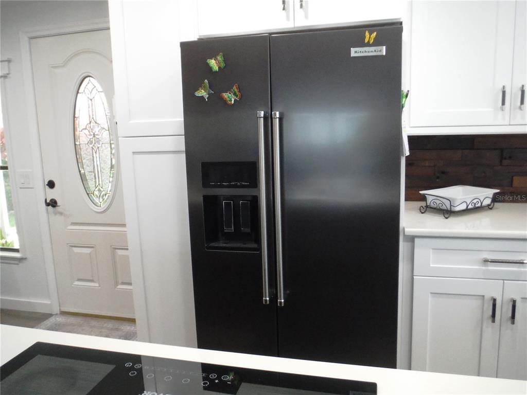 168 Pinewood Terrace, Unit 104 Safety Harbor, FL 34695 - Photo 11 of 55 a kitchen with a refrigerator and cabinets