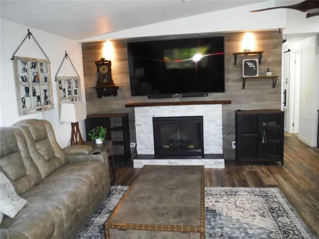 a living room with fireplace and a wooden floor