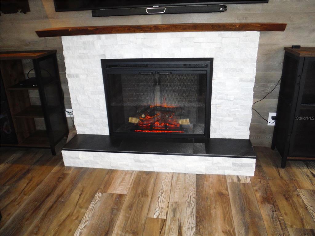 168 Pinewood Terrace, Unit 104 Safety Harbor, FL 34695 - Photo 15 of 55 a living room with fireplace and a wooden floor