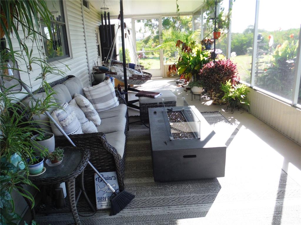 168 Pinewood Terrace, Unit 104 Safety Harbor, FL 34695 - Photo 17 of 55 a view of a patio with table and chairs potted plants with wooden floor